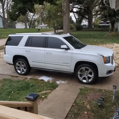 White GMC Yukon Denali exterior after full detail showing gleaming paint and polished chrome wheels